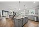 Open-concept kitchen with an island featuring granite countertops, stainless appliances, and wood flooring at 200 Gill Farm Way, Franklinton, NC 27525