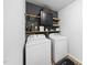 A laundry room equipped with a front-loading washer, a dryer, and shelving at 200 Gill Farm Way, Franklinton, NC 27525