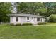 Charming one-story home with a well-manicured lawn and mature trees, creating a serene and inviting atmosphere at 2015 Walnut St, Durham, NC 27705