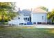 Exterior of home with a sloped lawn, deck with ramp and an abundance of trees at 208 Glenn St, Franklinton, NC 27525