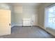 A bedroom with carpet, neutral paint, and white trim, featuring a window, and an alcove at 208 Glenn St, Franklinton, NC 27525