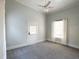 A bedroom with tall ceilings, carpet, neutral paint and white trim featuring a window and door at 208 Glenn St, Franklinton, NC 27525