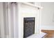 Close-up of a fireplace featuring white pillars, patterned tile, and an ornamental iron cover at 208 Glenn St, Franklinton, NC 27525