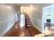 Inviting foyer featuring hardwood floors and traditional staircase; views of fireplace at 208 Glenn St, Franklinton, NC 27525