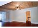 A spacious living room featuring a unique wood ceiling, ceiling fan, and hardwood floors at 208 Glenn St, Franklinton, NC 27525