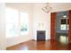 View of bright living room featuring fireplace, hardwood floors, chandelier, and large windows at 208 Glenn St, Franklinton, NC 27525