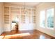Sun-filled living room featuring hardwood floors, custom built-ins, and classic chandelier at 208 Glenn St, Franklinton, NC 27525