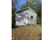 A stand alone outbuilding painted light grey with a white door and trim at 208 Glenn St, Franklinton, NC 27525