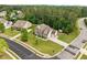 Aerial view of brick two-story home on landscaped corner lot in a wooded neighborhood at 21 Botanical Way, Pittsboro, NC 27312