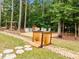 Landscaped backyard featuring a wood bench, a fire pit, and small wooden bridge at 21 Botanical Way, Pittsboro, NC 27312