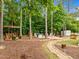 Landscaped backyard featuring a wood bench and a fire pit near the house at 21 Botanical Way, Pittsboro, NC 27312