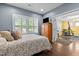 Bedroom leading to home gym, features a bed, wood floors, and natural light at 21 Botanical Way, Pittsboro, NC 27312