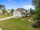 Back exterior view of a two-story home with lawn, a screened in porch and long driveway at 21 Botanical Way, Pittsboro, NC 27312