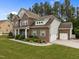 Traditional brick home with well-manicured lawn, mature trees and attached garage at 21 Botanical Way, Pittsboro, NC 27312