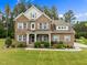 Charming two-story brick home with a covered front porch, landscaped yard, and inviting curb appeal at 21 Botanical Way, Pittsboro, NC 27312