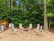 Gravel backyard area with six chairs surrounding a brick fire pit at 21 Botanical Way, Pittsboro, NC 27312