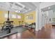 Bright home gym featuring hardwood floors, exercise equipment, coffered ceilings, and natural light at 21 Botanical Way, Pittsboro, NC 27312