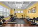 Home gym with hardwood floors, coffered ceiling, large window, and a full array of exercise equipment at 21 Botanical Way, Pittsboro, NC 27312