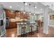 Gourmet kitchen with dark wood cabinets, granite countertops, stainless steel appliances, and an island with bar seating at 21 Botanical Way, Pittsboro, NC 27312
