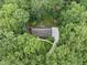 Aerial view of a property nestled among green trees, showcasing roof and surrounding landscape at 2300 Valley Forge Dr, Raleigh, NC 27615