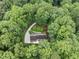 Aerial view features a home nestled in a lush forest setting with manicured lawns at 2300 Valley Forge Dr, Raleigh, NC 27615