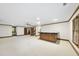 Basement area with a functional wet bar, wood trim, and neutral carpet flooring at 2300 Valley Forge Dr, Raleigh, NC 27615