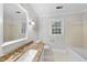 Well-lit bathroom featuring granite countertops, a bathtub, and a window at 2300 Valley Forge Dr, Raleigh, NC 27615