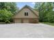 A two-car garage with brick accents and neutral-colored siding, framed by lush greenery at 2300 Valley Forge Dr, Raleigh, NC 27615