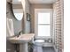Cozy bathroom features a pedestal sink, tiled floor, and patterned shower curtain at 2303 Byrd St, Raleigh, NC 27608