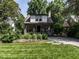 Charming two-story home featuring a landscaped yard with vibrant green grass and mature trees at 2303 Byrd St, Raleigh, NC 27608