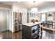 Elegant kitchen features white cabinetry, stainless steel refrigerator and a center island with seating at 2303 Byrd St, Raleigh, NC 27608