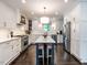 Bright kitchen features white cabinets, stainless steel appliances, and center island with seating at 2303 Byrd St, Raleigh, NC 27608