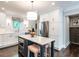Well-lit kitchen with a stainless steel fridge, center island, and bright white cabinetry at 2303 Byrd St, Raleigh, NC 27608