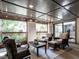 The enclosed sunroom is furnished with comfortable seating and overlooks the lush backyard at 2303 Byrd St, Raleigh, NC 27608