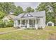 Charming home with a welcoming porch, dark shutters, and a well-manicured lawn at 2418 Highland Ave, Durham, NC 27704