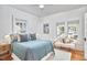 Brightly lit bedroom with a ceiling fan, two windows, and hardwood floors at 2418 Highland Ave, Durham, NC 27704