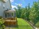 Grassy backyard with a wooden deck, screened porch, and fenced-in lawn, offering privacy at 2636 Nordmann Fir Rd, Raleigh, NC 27616
