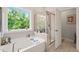 Bathroom featuring a soaking tub, glass enclosed shower and view of mature trees at 2636 Nordmann Fir Rd, Raleigh, NC 27616