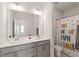 Well-lit bathroom with double vanity, modern fixtures, and a playful shower curtain at 2636 Nordmann Fir Rd, Raleigh, NC 27616