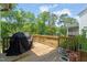 Wooden deck perfect for outdoor grilling and dining, featuring a grill and planters with green foliage at 2636 Nordmann Fir Rd, Raleigh, NC 27616