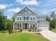Charming two-story home with a manicured lawn, lush landscaping, and inviting front porch at 2636 Nordmann Fir Rd, Raleigh, NC 27616