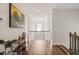 Bright hallway featuring hardwood floors, white walls, wooden railing, and a Van Gogh print at 2636 Nordmann Fir Rd, Raleigh, NC 27616