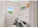 Efficient laundry room featuring a modern washer and dryer, ample shelving and a bright window at 2636 Nordmann Fir Rd, Raleigh, NC 27616