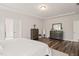 Well-lit main bedroom features hardwood floors, white bedding, and dual dressers with a ceiling fan at 2636 Nordmann Fir Rd, Raleigh, NC 27616