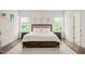 Bright bedroom with three windows, hardwood floors, area rug and a king size bed at 2636 Nordmann Fir Rd, Raleigh, NC 27616