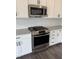 Close-up of a stainless steel gas range and microwave in a modern kitchen with white cabinets at 269 Hank Way, Angier, NC 27501