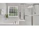 Bright bathroom with a soaking tub, window, and glass enclosed shower at 2744 Laurelcherry St, Raleigh, NC 27612