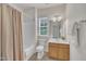 Well-lit bathroom featuring a shower-tub combo with a beige shower curtain and a wood vanity with a white countertop at 2744 Laurelcherry St, Raleigh, NC 27612