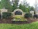 Stone community sign for The Townes at Crabtree, surrounded by lush landscaping and greenery at 2744 Laurelcherry St, Raleigh, NC 27612