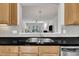Kitchen featuring a stainless steel sink, black countertop, tiled backsplash, and open view to the living room at 2744 Laurelcherry St, Raleigh, NC 27612